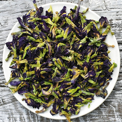 Clitoria ternatea butterfly pea flower tea whole dried blue flowers displayed on a white plate