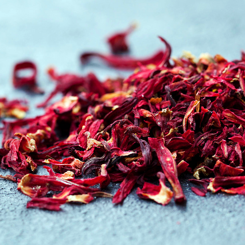 Macro close-up of dried Hibiscus × rosa-sinensis flower petals showing natural crimson and burgundy texture