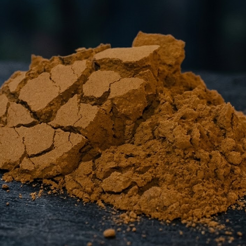 Macro photograph of reddish brown Peruvian Chuchuhuasi bark powder and its natural cracked texture on a dark surface