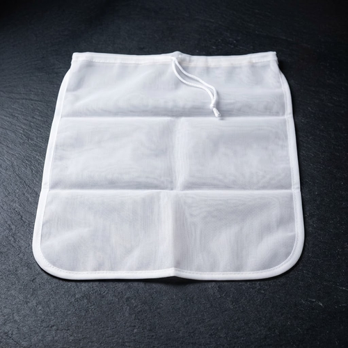 Sacred Plants Australia white nylon kava strainer bag laid flat with open drawstring on dark stone, for preparing Piper methysticum kava.