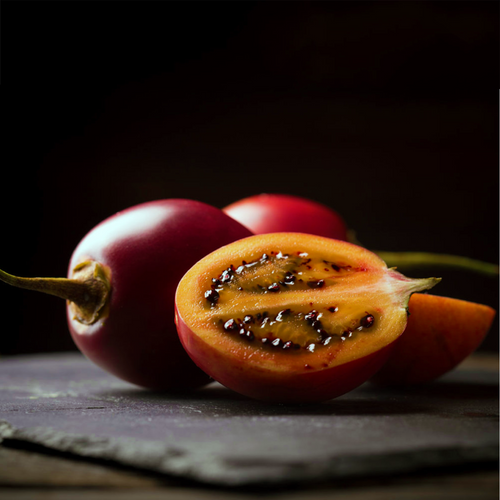 Red Tamarillo, Solanum betaceum, ripe fruit cut open to reveal orange flesh and dark seeds