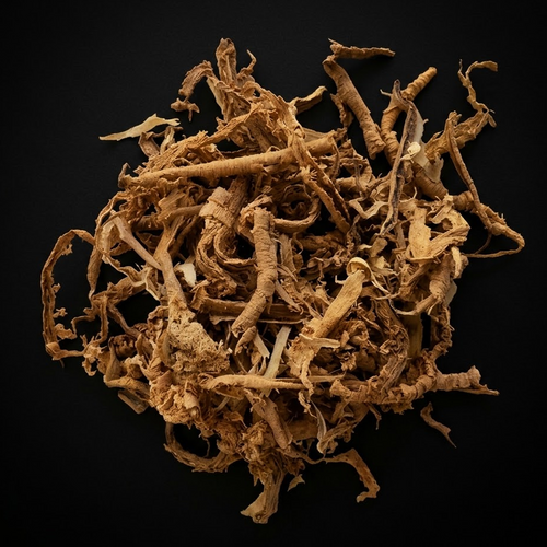 Overhead studio photograph of dried Sananga root bark and fibrous botanical strips arranged in a loose mound on a matte black background.