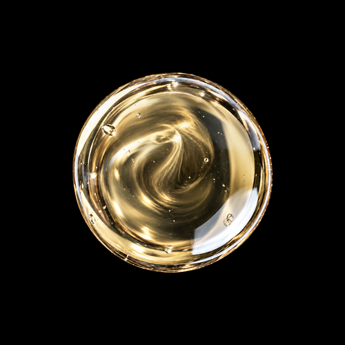 Chios Mastic Resin Infused Oil — pale golden oil swirl overhead macro on black