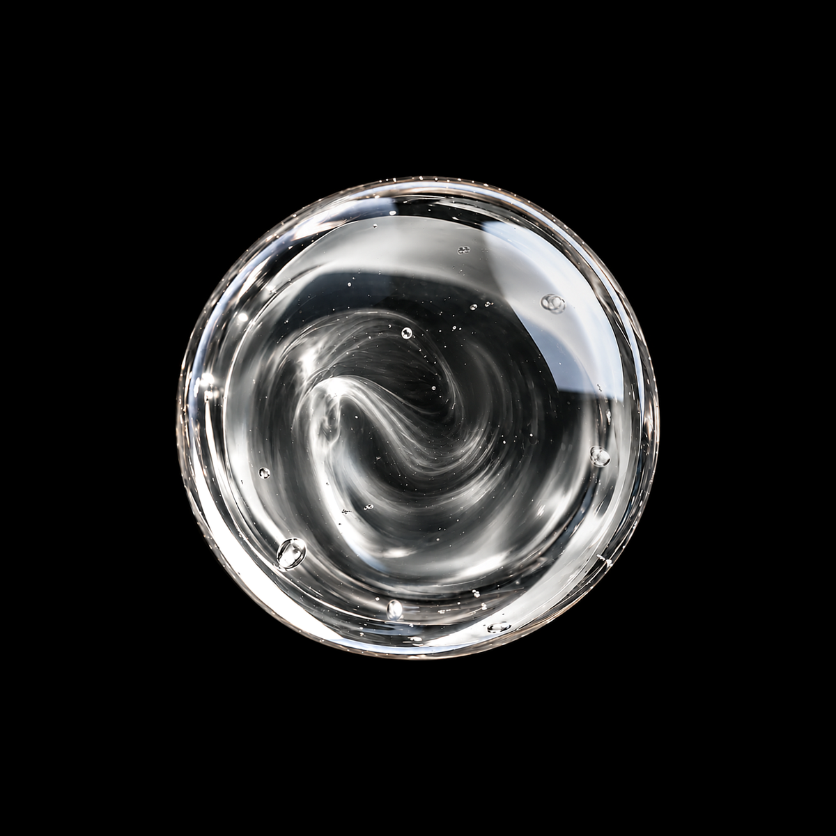 Dhofar Frankincense Essential Oil — clear essential oil swirl overhead macro on black
