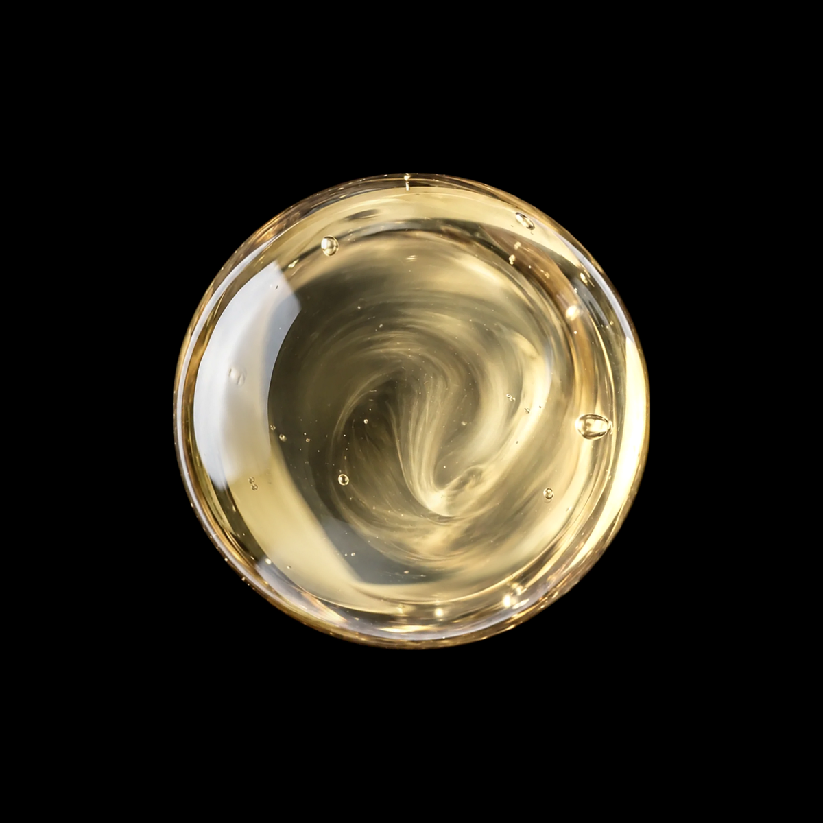 Dhofar Frankincense Resin Infused Oil — pale golden oil swirl overhead macro on black