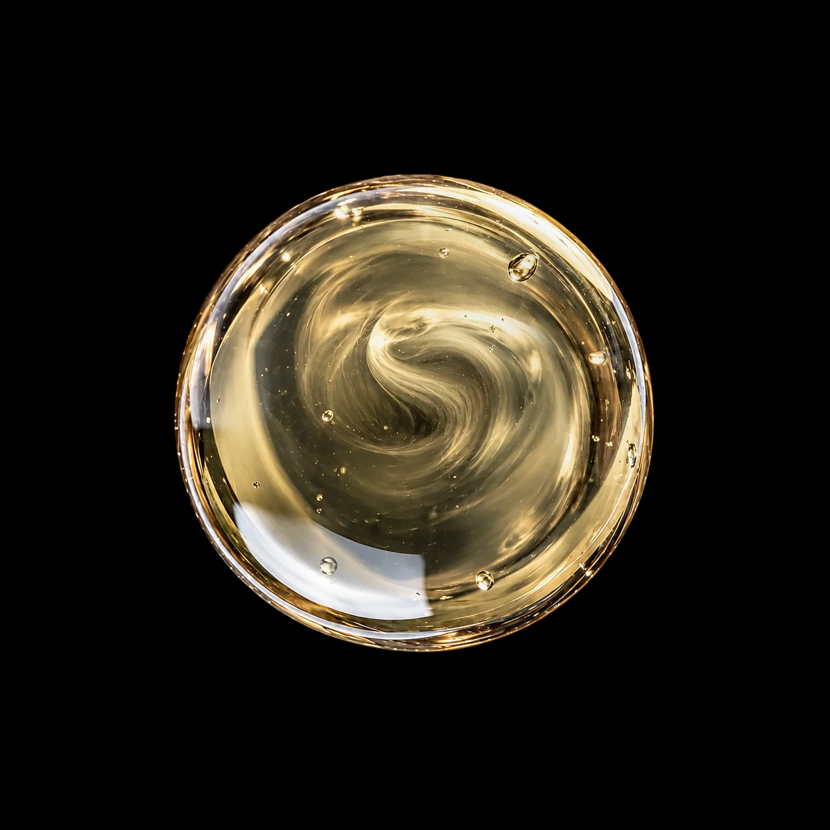 Mexican White Copal Resin Infused Oil — subtly hazy pale oil swirl overhead macro on black