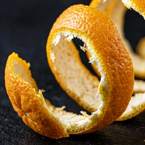 Ultra-close view of curled bitter orange peel against a dark background