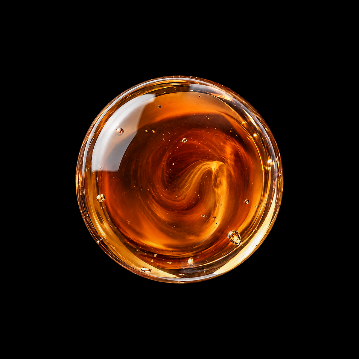 Yemeni Myrrh Resin Infused Oil — reddish amber oil swirl overhead macro on black