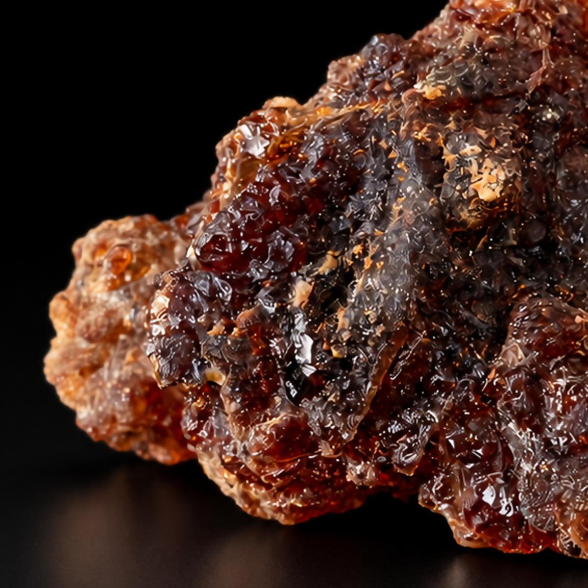 Extreme macro detail of dark amber-brown Yemeni myrrh resin tears on black.